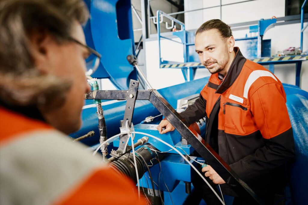 Zwei Mitarbeiter verbinden Wasserstoffrohre im voestalpine Werk