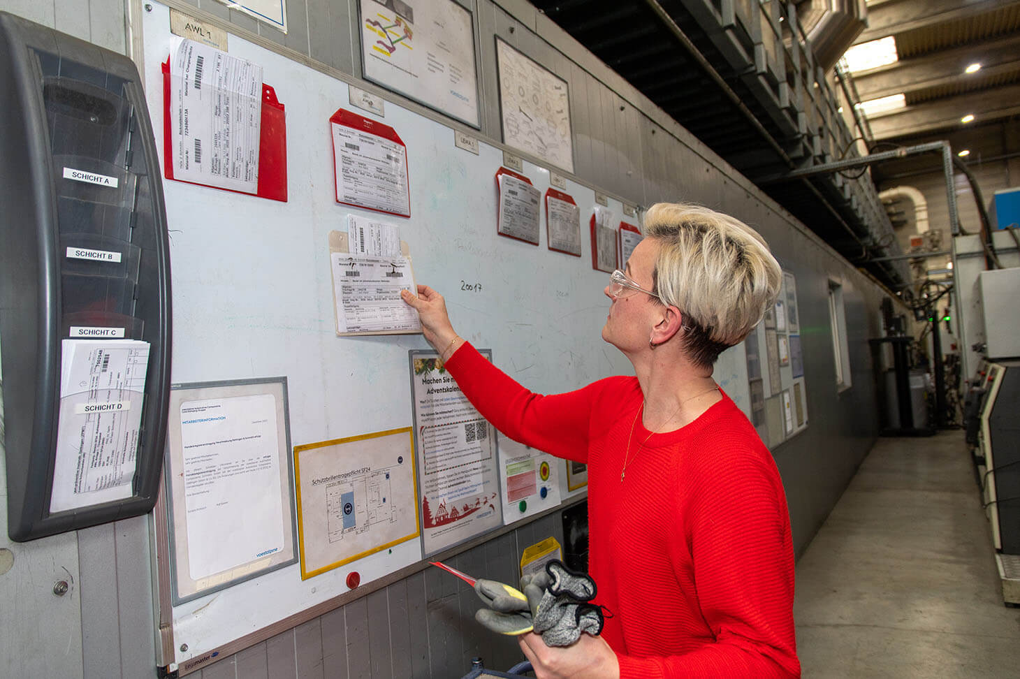 Fabienne Krause hangs information on the wall on which shift schedules are displayed