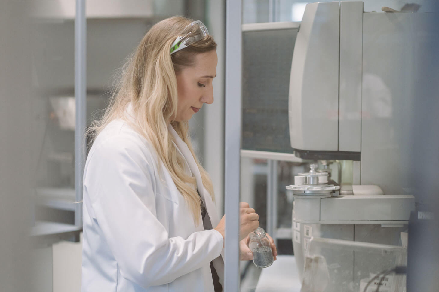 Junge Frau im Labor steht vor einem Mikroskop