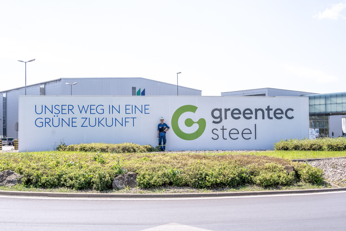 Schild unser Weg in eine grüne Zukunft, greentec steel, davor posiert ein Mitarbeiter