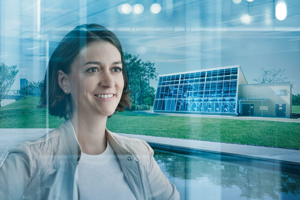 imagefoto voestalpine, eine Mitarbeiterin und im Hintergrund die Glasfassade der h3future Anlage