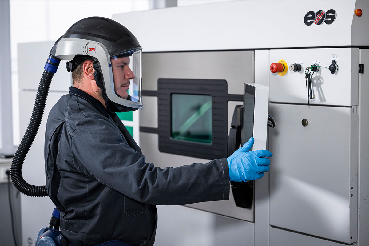 Bastian bedient einen industriellen 3D-Drucker im Additive Manufacturing Center