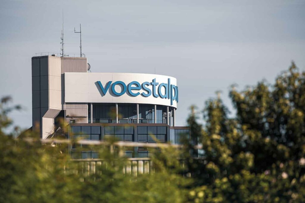 Long-distance shot of the blue voestalpine headquarters tower with voestalpine lettering