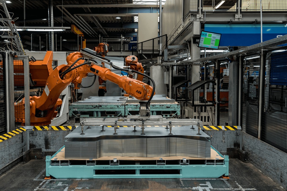 Roboter zur Stapelung von Stahlplatten in einer Werkshalle für voestalpine-Produkte im Automotive-Bereich