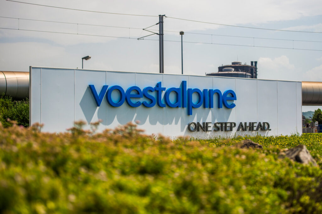 Very large sign with the logo of voestalpine in linz and the text "one step ahead"