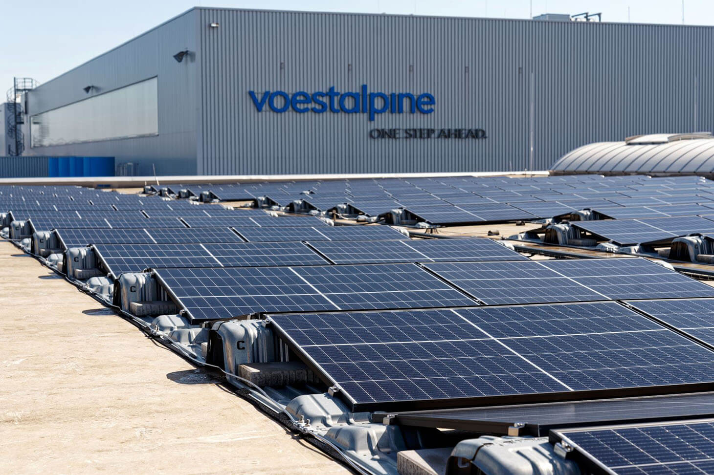 Viele Reihen von Photovoltaik Modulen auf einem Werksgebäude der voestalpine