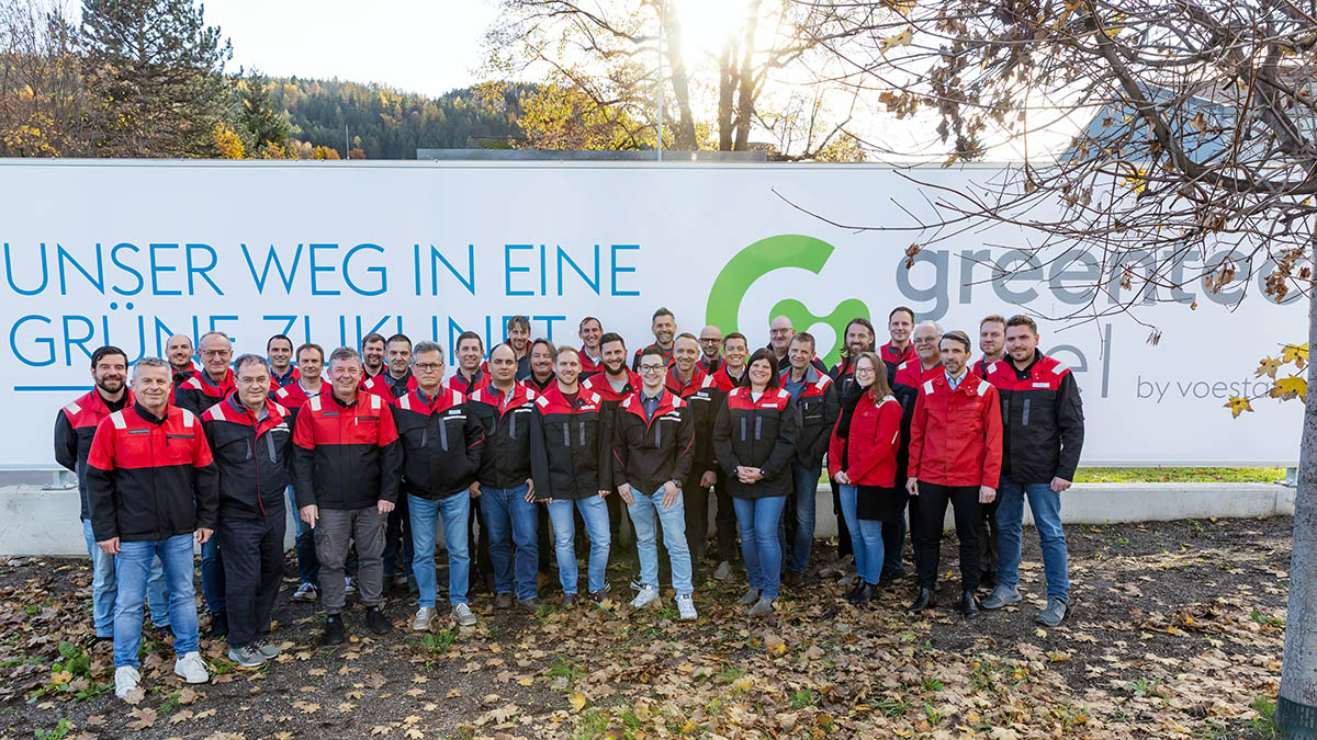 Group photo greentec steel in front of the banner our path to a green future