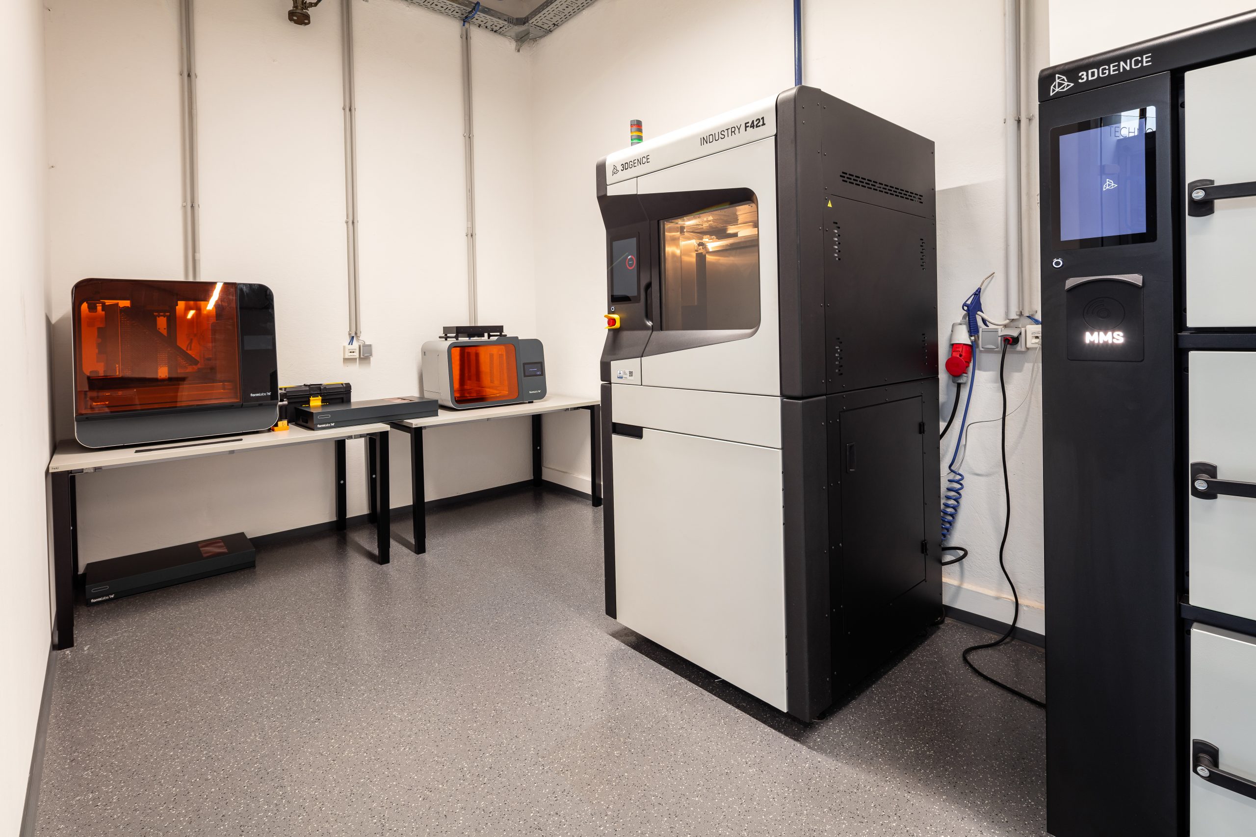 Innenansicht des modernen voestalpine 3D-Druck-Kompetenzzentrums mit industriellen 3D-Druckern und Arbeitsbereichen für additive Fertigung.