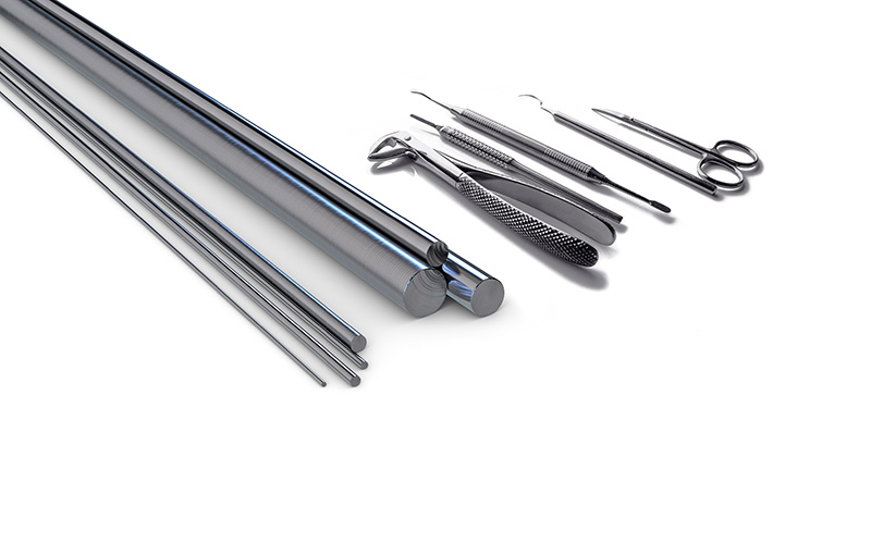 Metal medical instruments and precision rods for surgical or dental applications on a white background.
