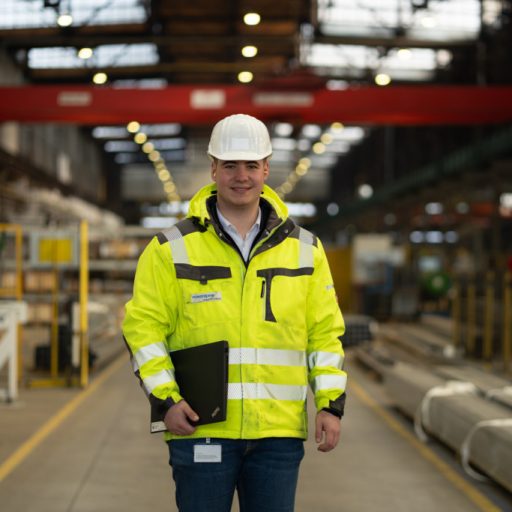 Mitarbeiter in der Produktion verbindet digitale Arbeitsprozesse mit industrieller Fertigung in einer modernen Produktionsumgebung.