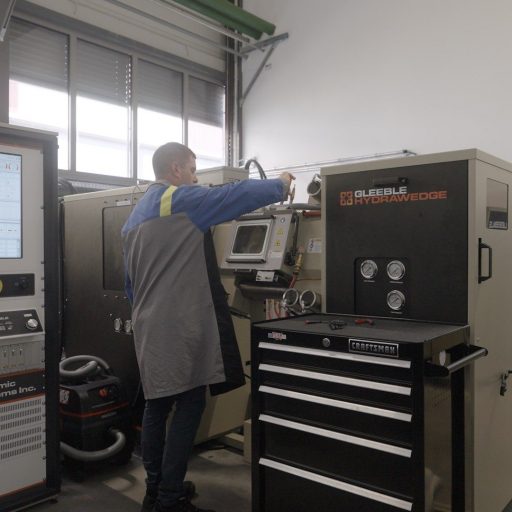 Christian H. operates a GLEEBLE HYDRAWEDGE testing device at a voestalpine facility – material testing to ensure the highest quality in metal processing.