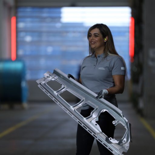 voestalpine employee holds a steel component in the production hall