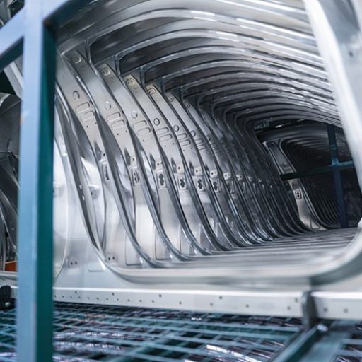 View through multiple aligned metal body structures in an industrial production facility.