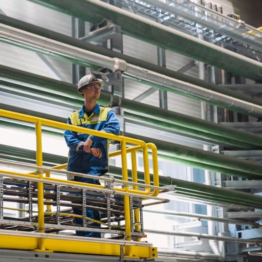 Mitarbeiter in Schutzkleidung an ein Geländer gelehnt im neuen Edelstahlwerk