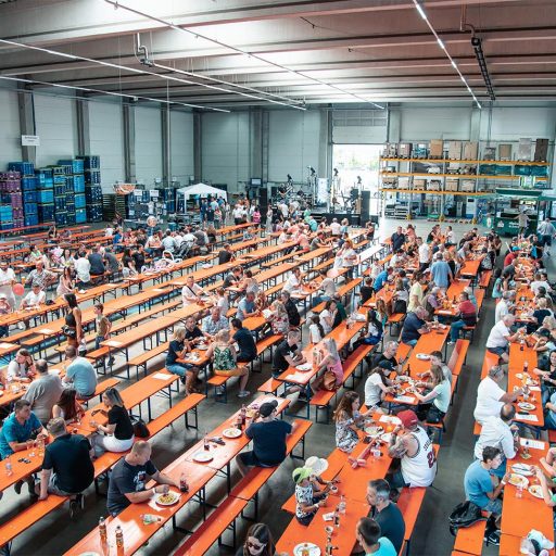 Bierbankgarnituren mit zahlreichen Besuchern des Sommerfestes im Werk Dettingen