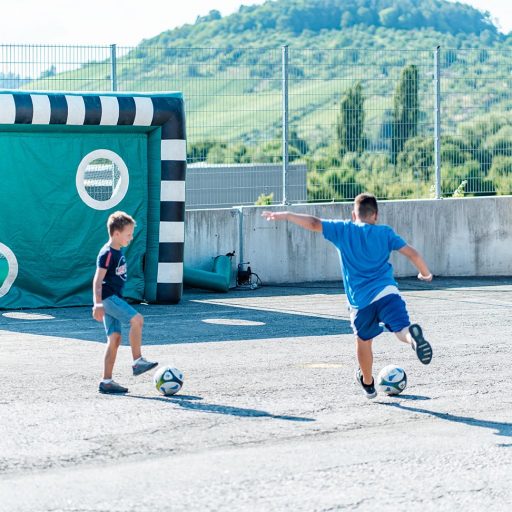 Kinder spielen an der Fußballtorwand beim Sommerfest