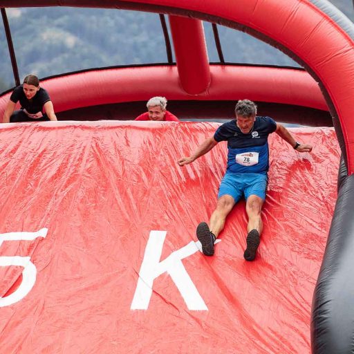 Drei Teilnehmer auf der Rutsche des Hindernislaufes