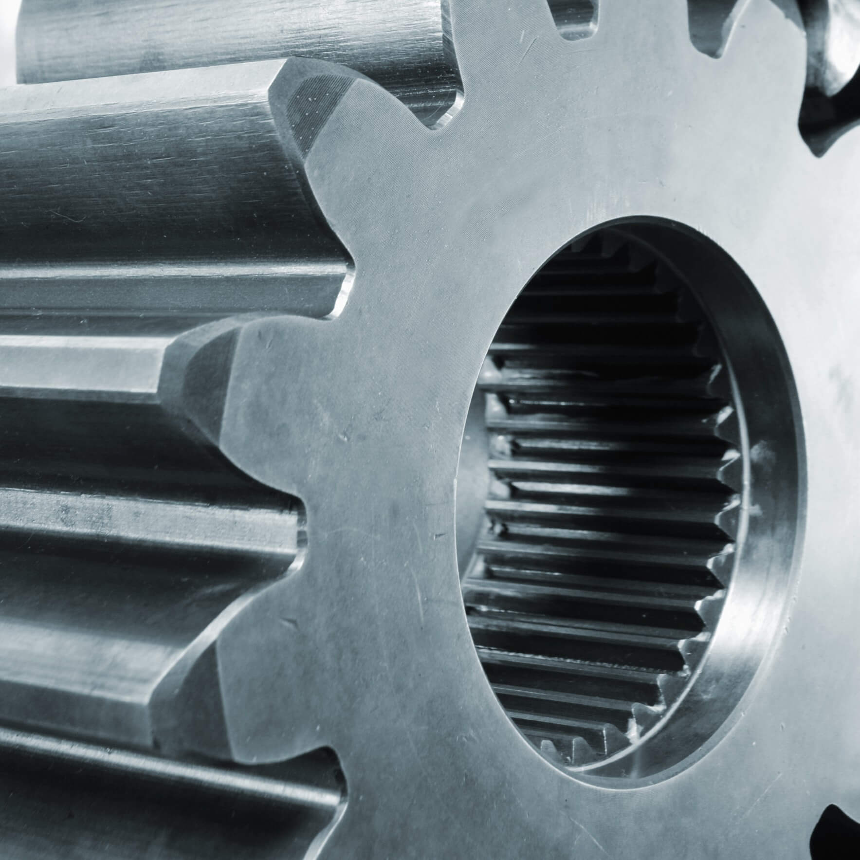 Nahaufnahme eines großen Titanzahnrads mit sichtbaren Zähnen und einem inneren Ring mit kleineren Zähnen, der die Textur des Zahnrads und das von Titan inspirierte Industriedesign hervorhebt.