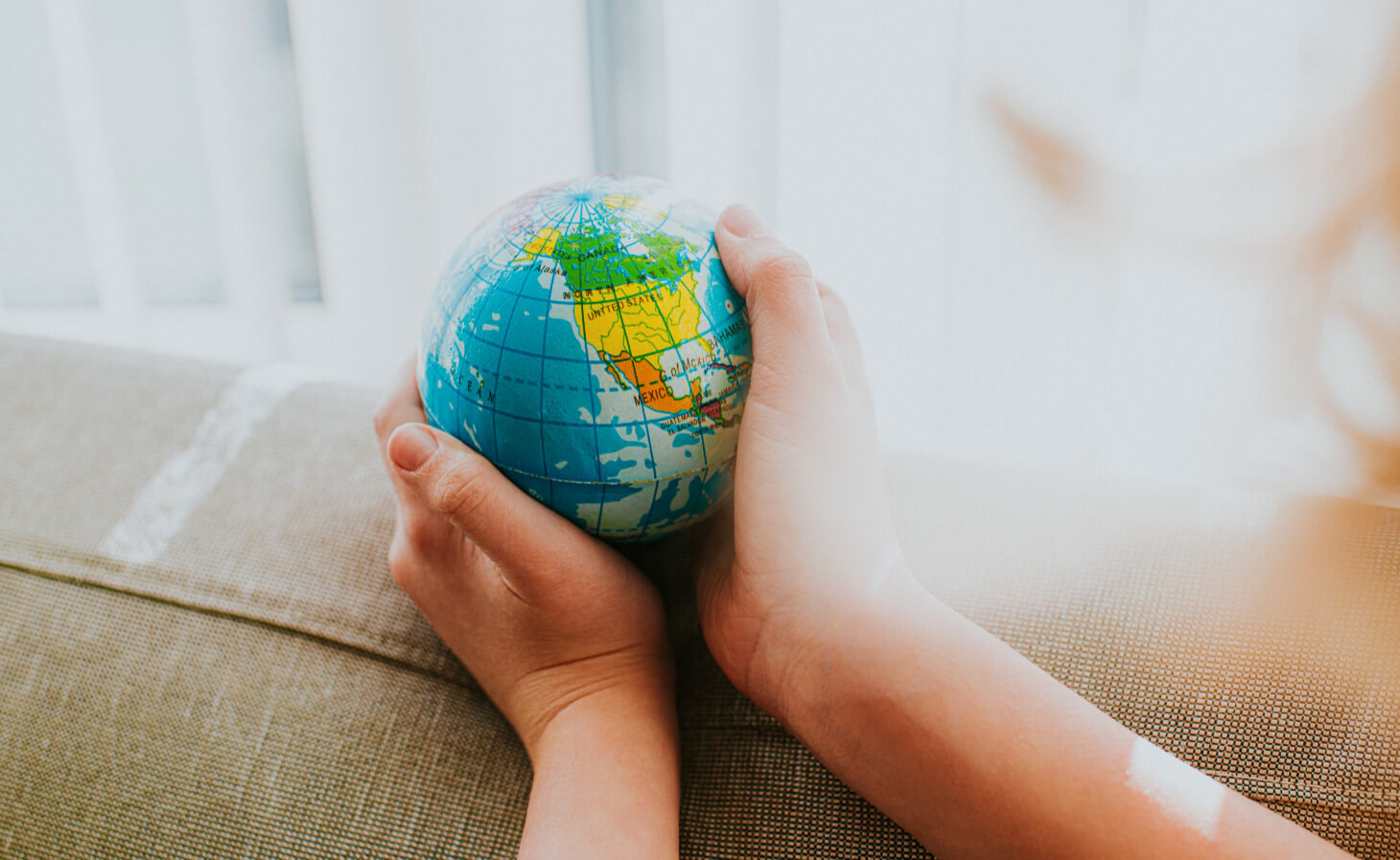 Childs hands around a Globe