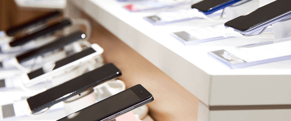 Two shop shelves displaying mobile phones.