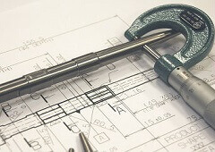 steel tools laid on top of a technical drawing