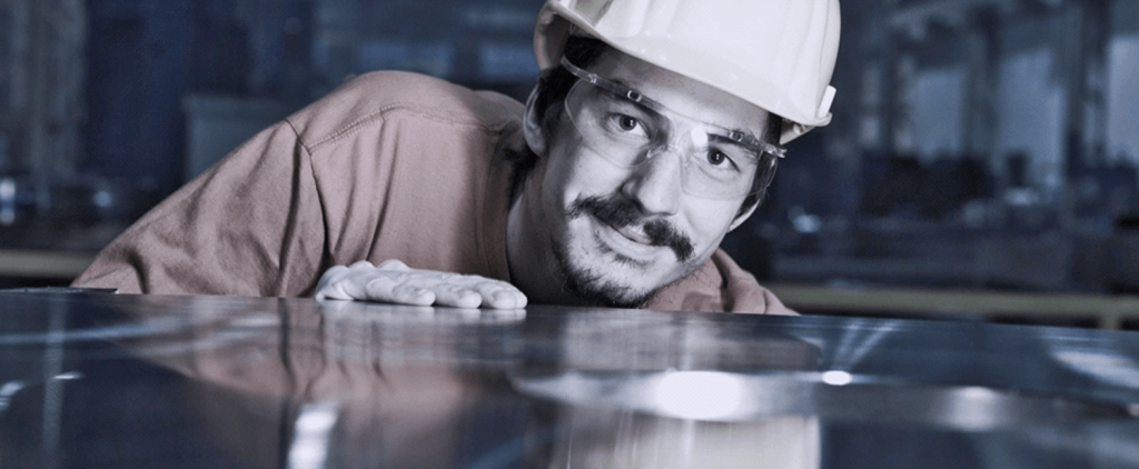 Mann mit Schutzbrille und Helm lächelt in die Kamera
