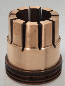 Componente cilíndrico de cobre con ranuras verticales espaciadas uniformemente alrededor de la parte superior, que presenta una base con anillos circulares oscuros.
