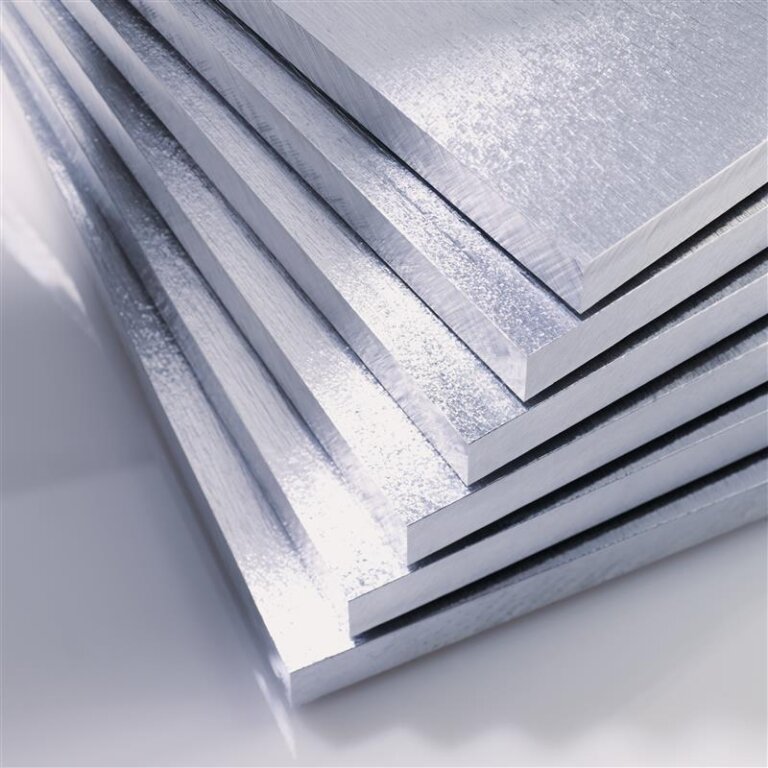A close-up view of several stacked, shiny aluminum sheets with smooth surfaces and sharp edges, reflecting light to create a metallic sheen.