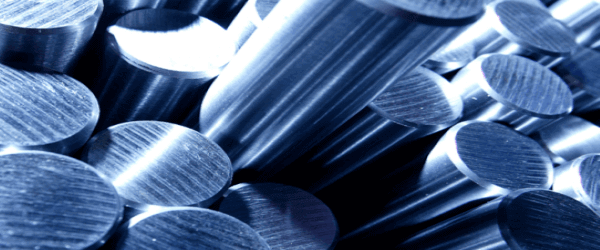 Close-up view of several cylindrical metal rods made of tool steel with a shiny, brushed surface, stacked closely together and illuminated with blue-tinted light, ideal for various tooling applications.