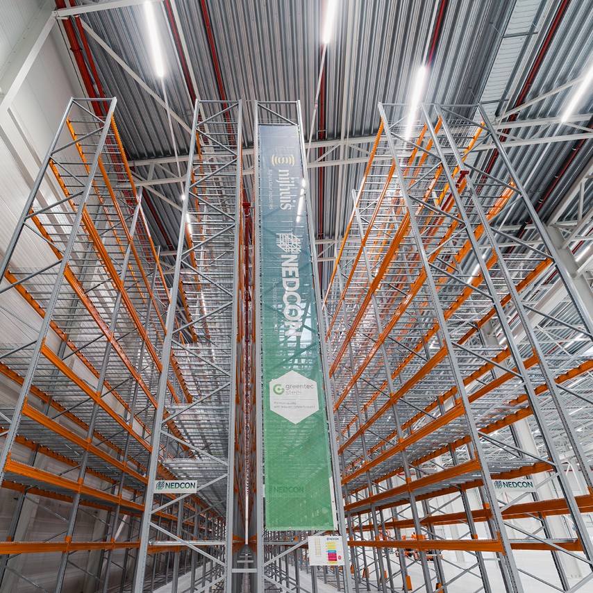 The new warehouse features a striking green color scheme and is adorned with the logos of its partners.