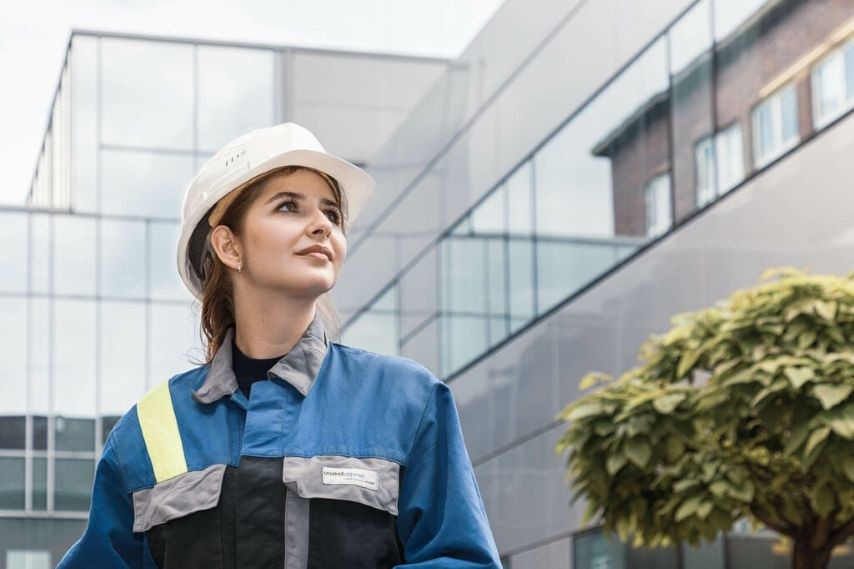 Mitarbeitende in Schutzausrüstung auf einem Industriegelände.