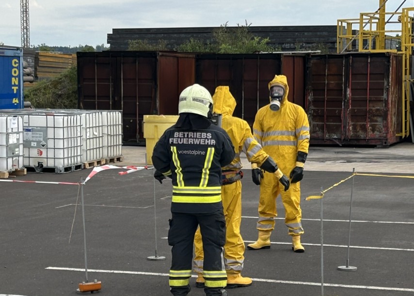 Einsatzkräfte in Schutzanzügen bei einer Übung zur Bewältigung von Gefahrstoffereignissen.