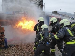 Feuerwehrkräfte bei einer Brandbekämpfungsübung mit Atemschutzgeräten.