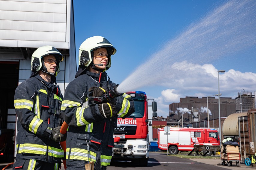 Mitarbeitende bei einer Feuerwehrübung zur Förderung von Sicherheit und Gesundheit am Arbeitsplatz.