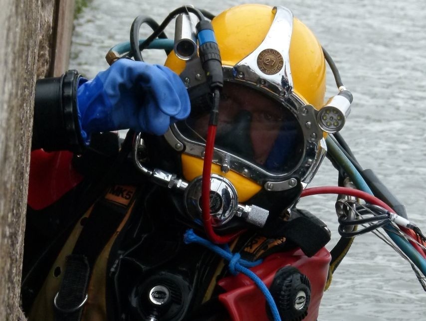 Feuerwehrtaucher in Spezialausrüstung bei einem Einsatz an einem Gewässer.