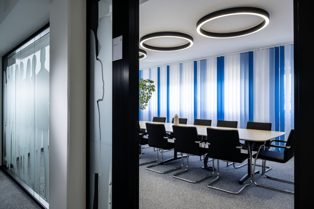 Moderner New-Work-Arbeitsbereich mit flexiblen Arbeitsplätzen und kollaborativen Zonen.