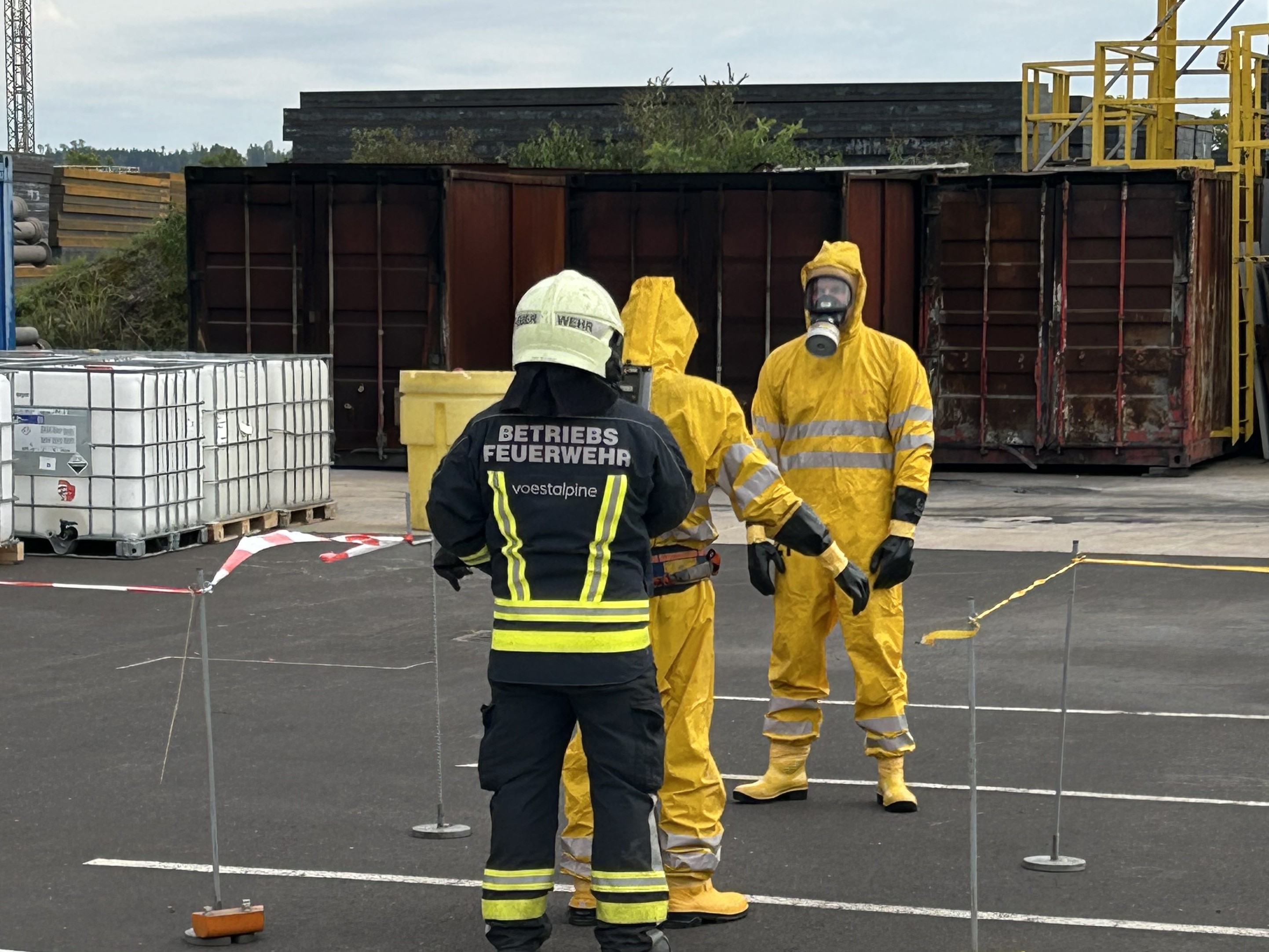 Einsatzkräfte in Schutzanzügen bei einer Strahlenschutzübung auf einem Betriebsgelände.