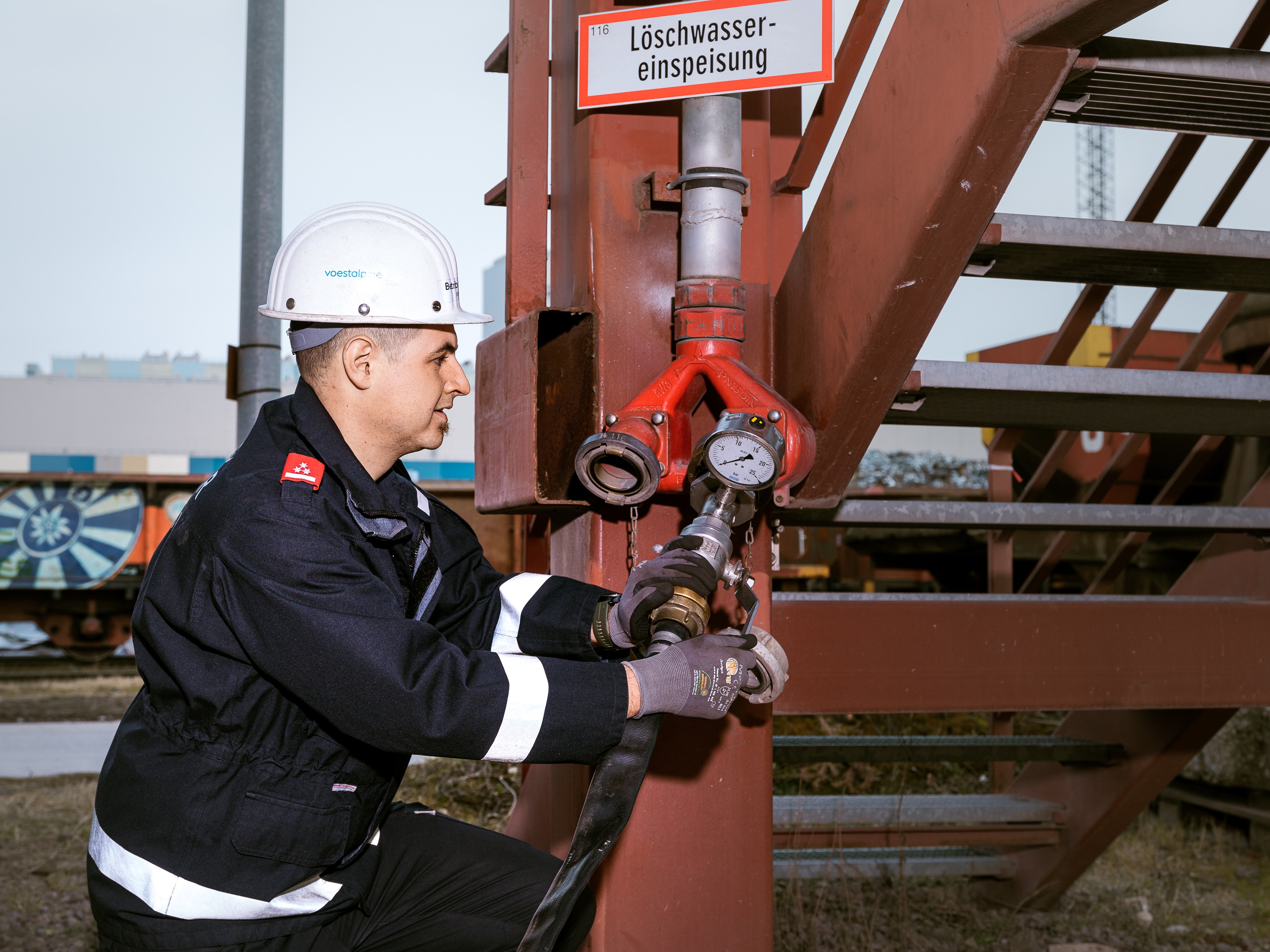 Mitarbeiter prüft eine Löschwassereinspeisung im Rahmen des vorbeugenden Brandschutzes.