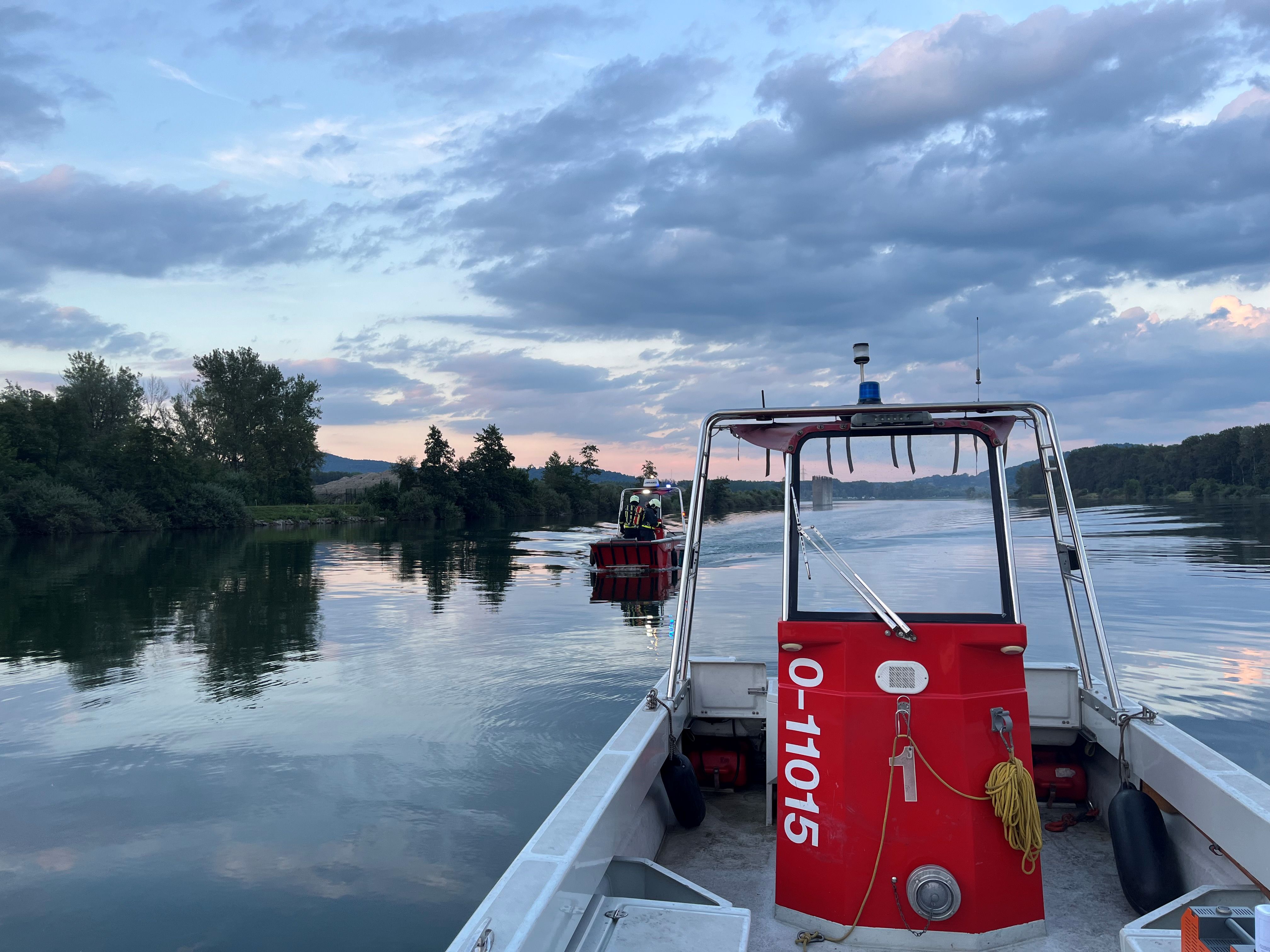 Feuerwehrboote bei einer Übungsfahrt auf einem Gewässer im Abendlicht.