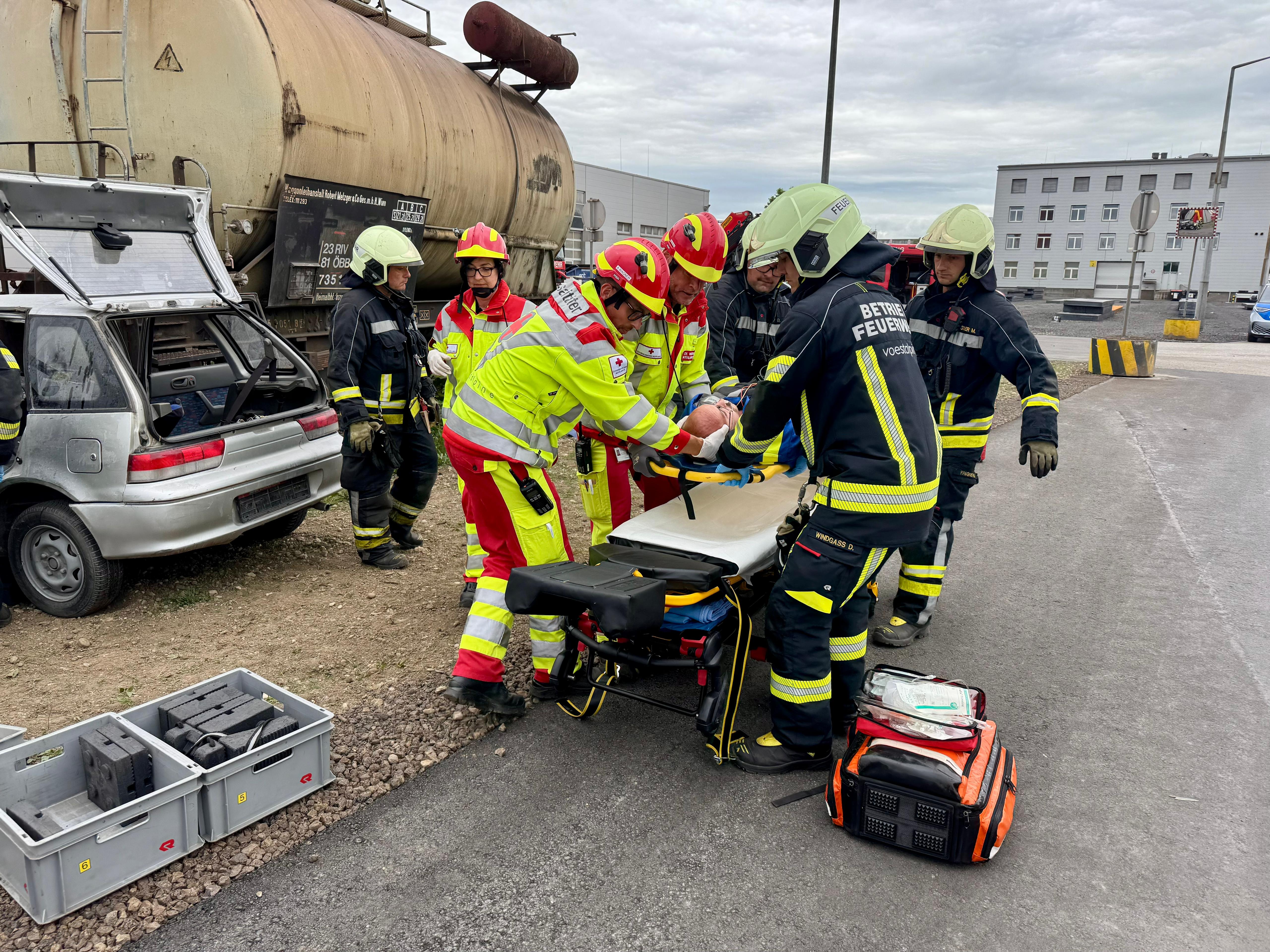 Betriebsrettung und Betriebsfeuerwehr bei der gemeinsamen Rettung einer verletzten Person auf einem Industriegelände.